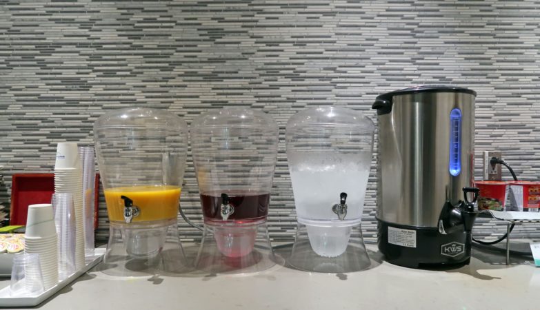 a group of water dispensers next to a silver container