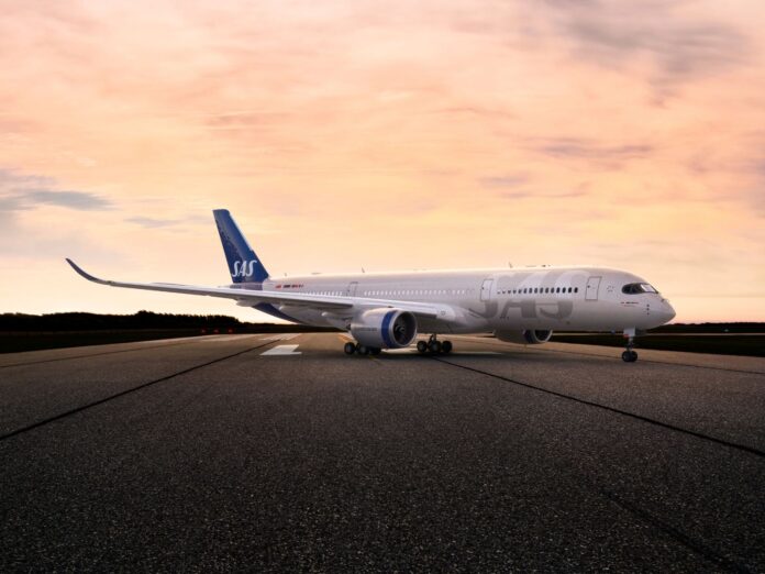 SAS plane landing at sunset